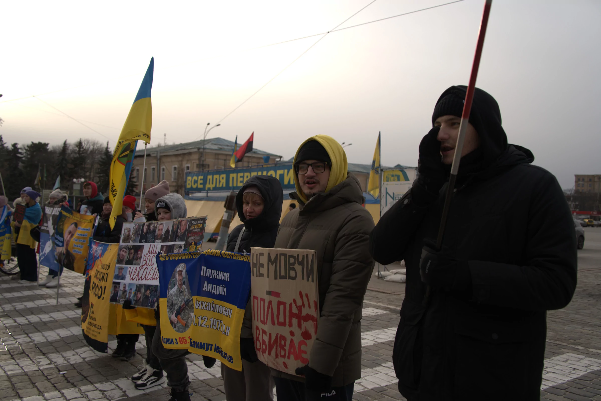 Ряд людей с плакатами на Площади Свободы в Харькове