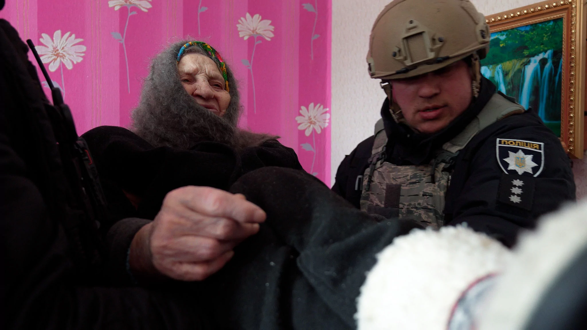 Волонтери заносять жінку з обмеженою мобільністю до швидкої