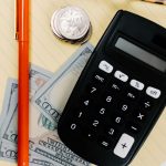 Калькулятор і банкноти для підрахунку комісій продажу